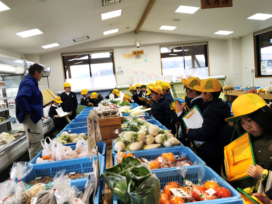 野菜売り場を見学する児童の写真